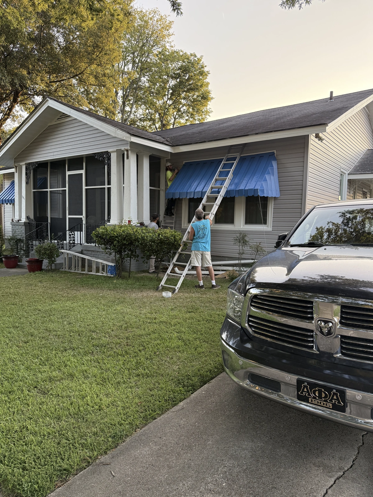 New windows and exterior work — home exterior with ladder and awning
