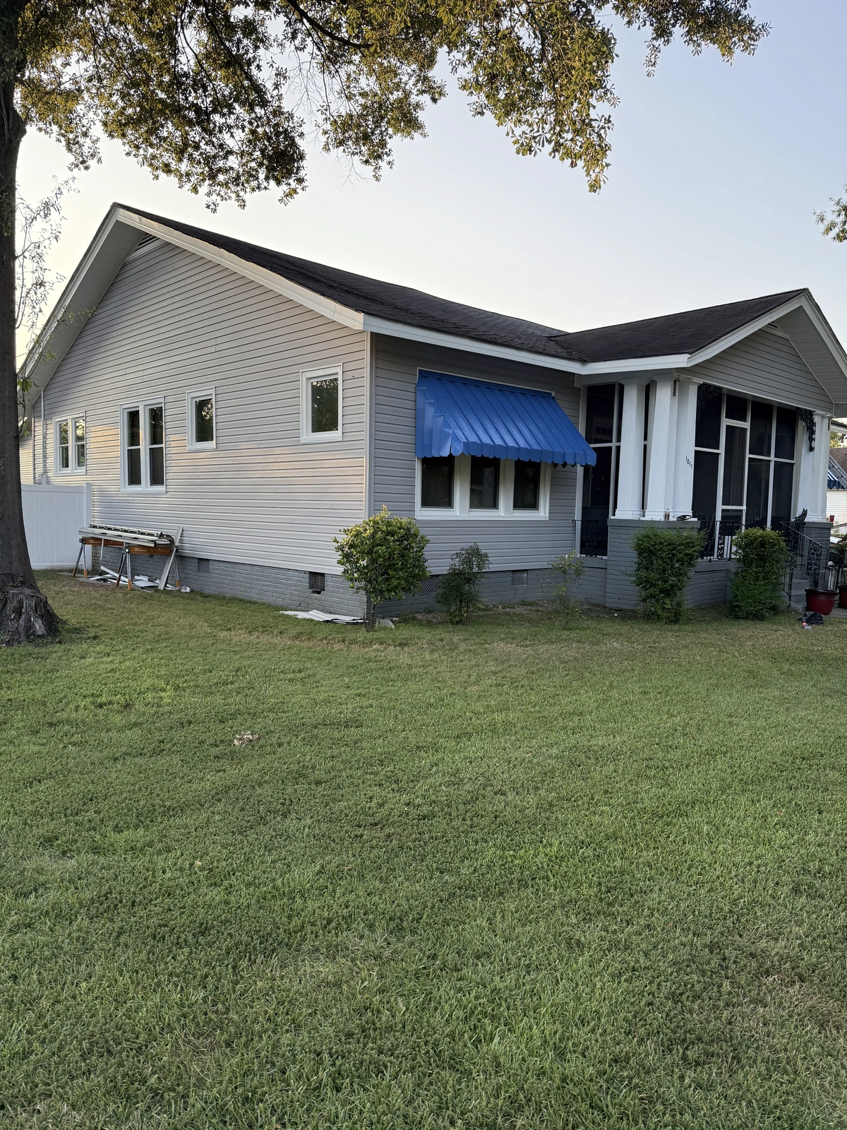 New windows and exterior work — new home with blue awning and landscaping
