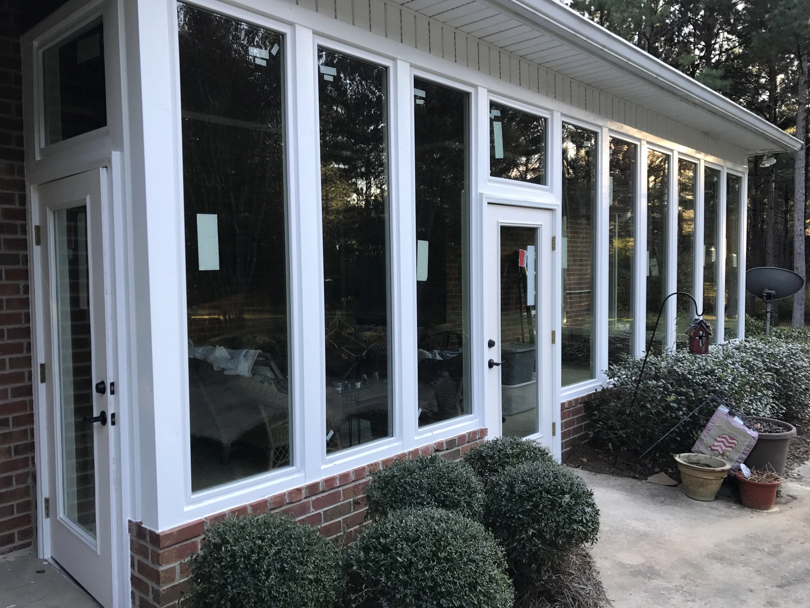 New windows and exterior work — with bushes and brick wall background
